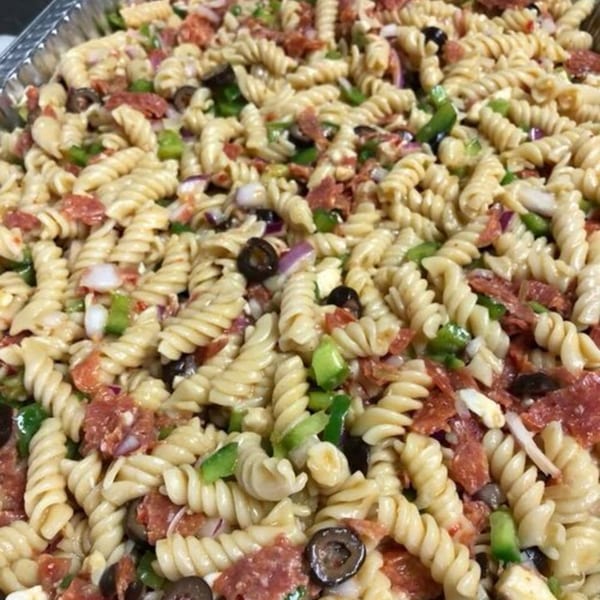 Close-up of Holy Smokes BBQ's pasta salad with rotini, pepperoni, olives, and green peppers.