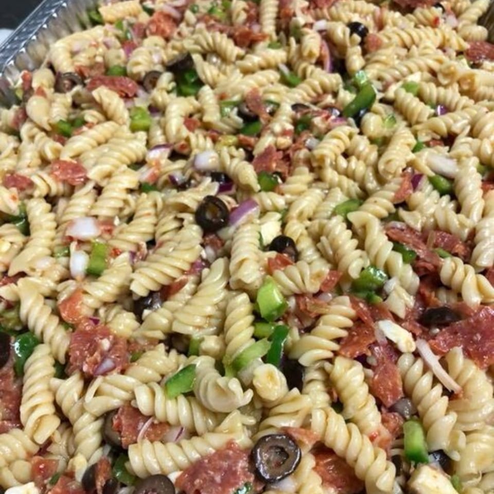 Close-up of Holy Smokes BBQ's pasta salad with rotini, pepperoni, olives, and green peppers.